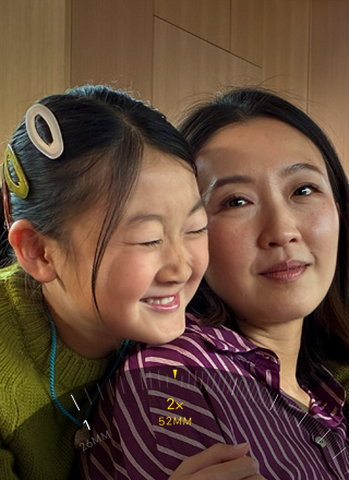 2x Telephoto feature in use, zooming in on two people hugging