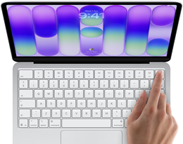 MacBook Neo, silver color, showing login screen, person's finger on Touch ID sensor in top-right corner of keyboard